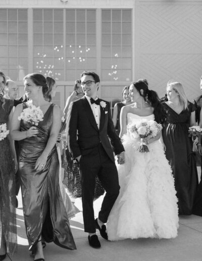 Groom wearing a custom tuxedo from Tailored Gents at Savile Row walking with his bride.