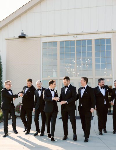 Groom wearing a custom wedding tuxedo from Tailored Gents at Savile Row walking with his groomsmen.