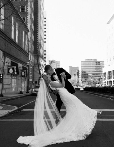 Groom wearing a custom tuxedo from Tailored Gents at Savile Row dipping his bride.
